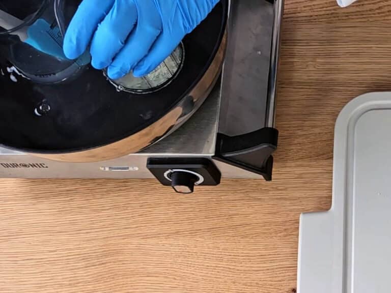 Place both of the beakers into a water bath Place both of the beakers into a water bath