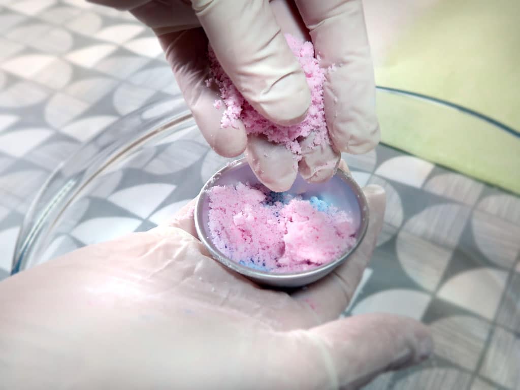 diy-multicolored-bath-bomb-recipe-c Adding bath bomb mixture to a bath bomb mold