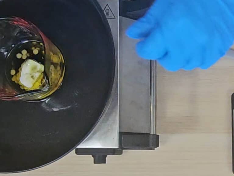 The heatproof container is placed in a water bath so the solid ingredients can melt The heatproof container is placed in a water bath so the solid ingredients can melt