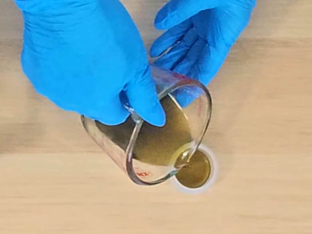 The mixture is poured into a small lip balm pot to store