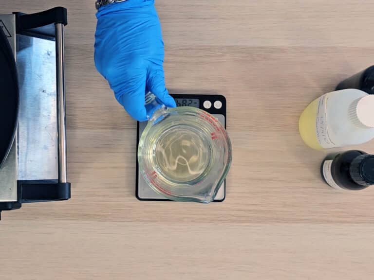 The beaker of melted ingredients are placed on a digital scale
