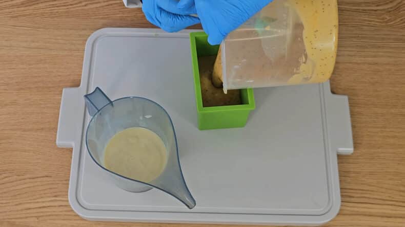 spoon the Annatto and clay batter into the mold.