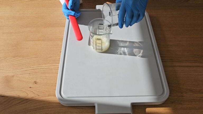 combine by pouring the beaker holding the water into the beaker holding the melted oils combine by pouring the beaker holding the water into the beaker holding the melted oils