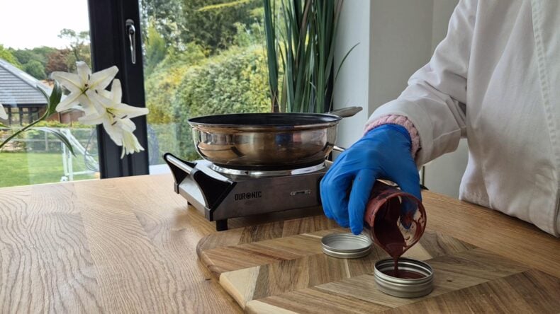 Whilst the tinted oils are still warm and fluid, pour them into your container