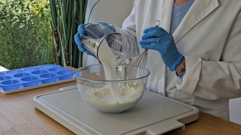 Adding citric acid to the shower steamer mixture while stirring with a whisk Adding citric acid to the shower steamer mixture while stirring with a whisk
